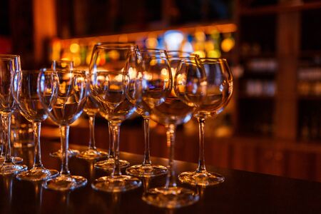 Glasses of wine and champagne stand on the bar in the light of the lights of the night barの写真素材