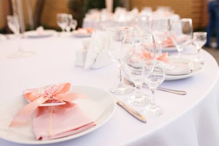 Glasses, forks, knives, plates on a table in restaurant served for dinnerの写真素材