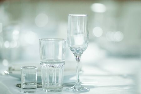 Empty glasses for wine and champagne in a row at the banquet tableの写真素材