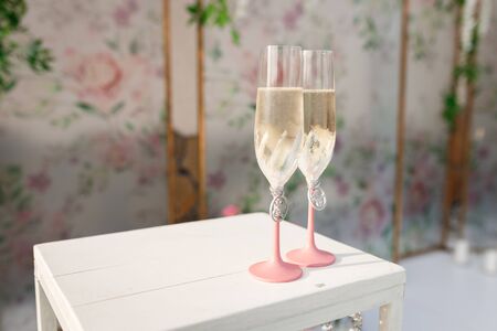 Glasses with champagne on the table for the bride and groom at the engagement ceremonyの写真素材