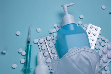 Hand sanitizer and medicines prevent covid-19 virus. Coronavirus concept on a blue background.の写真素材