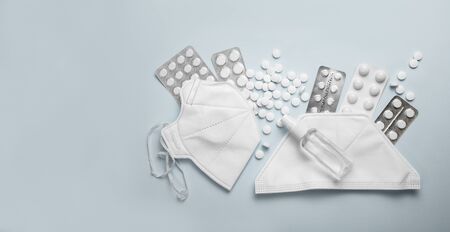 CORONAVIRUS concept flat lay on blue background with pills, sanitizer and protective masks.の写真素材