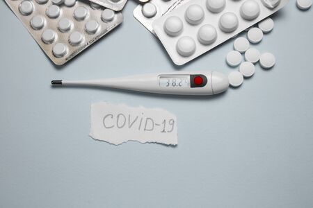 Tablets, pills and thermometer on a blue background. Flu cold concept. Healthcare medical concept. Medicine pill. Emergency medical treatment. Coronavirus medikament concept.の写真素材