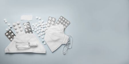 CORONAVIRUS concept flat lay on blue background with pills, sanitizer and protective masks.の写真素材