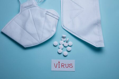 pills and protective mask on a blue background. Concept of medicine. Prevention of coronavirus.