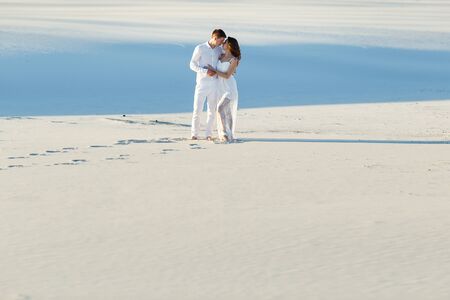 Newlyweds walk barefoot on the sand in the white desert. Love in the desert newlyweds.の写真素材