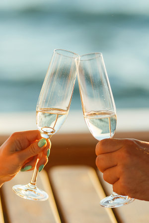 Happy couple drinks champagne on a yachtの写真素材