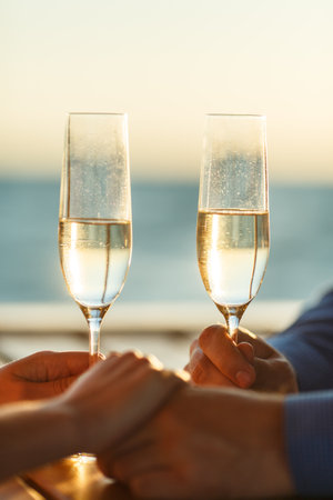 Happy couple drinks champagne on a yachtの写真素材