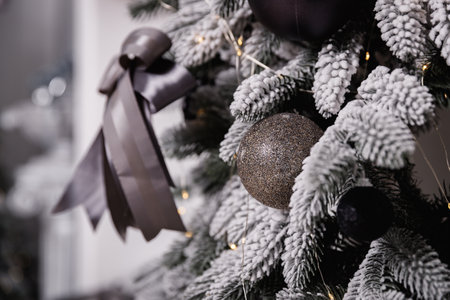 Black and white Christmas decoration on a snow-covered tree branch.の写真素材