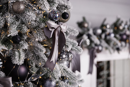 Black and white Christmas decoration on a snow-covered tree branch.の写真素材