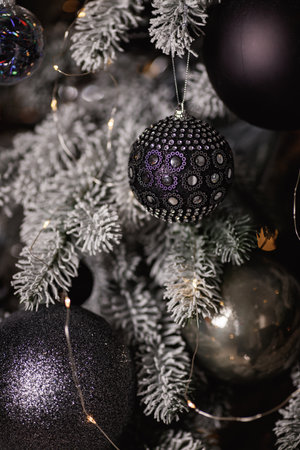 Black and white Christmas decoration on a snow-covered tree branch.の写真素材
