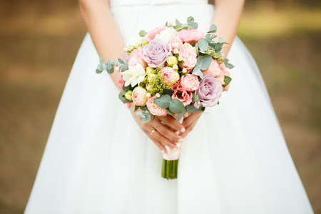 the bride holds the bouquet of flowers in her hand, the wedding floral bouquetの写真素材