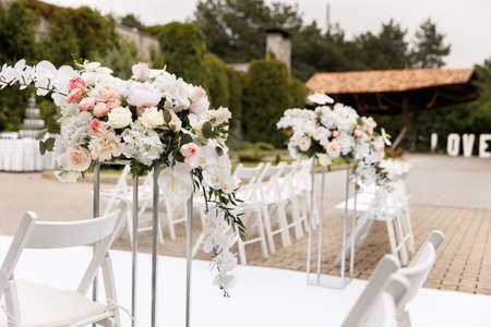 Wedding ceremony decorated with flowers and fabrics in light colors on the archの写真素材