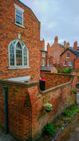 UK, Chester, 22.06.2021: View of the back wall of a red brick residential building with a large white windowのeditorial素材