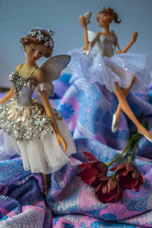 Christmas toys in the form of ballerinas. Artful faces in details, clothes on dolls made of light fabrics. Toys on a pale blue background with pearly glitter.の写真素材