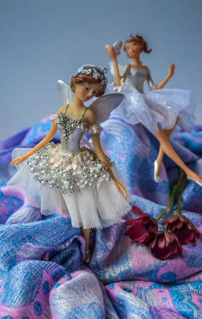 Christmas toys in the form of ballerinas. Artful faces in details, clothes on dolls made of light fabrics. Toys on a pale blue background with pearly glitter.の写真素材
