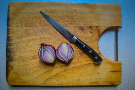 Sliced red onion and black knifeの写真素材