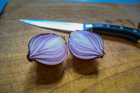 Sliced red onion and black knifeの写真素材