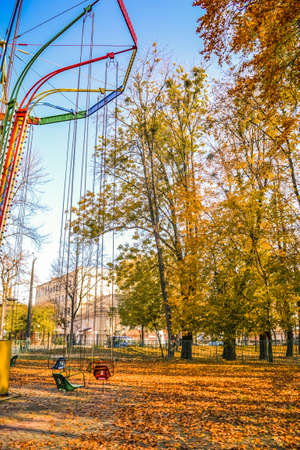 Old soviet rides in the autumn park. carousels with umbrellas and carousels on chains are brightly decorated in different colors. Ukraine.の写真素材