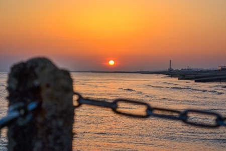 Ð¡hain link fence and sea sunset.の写真素材