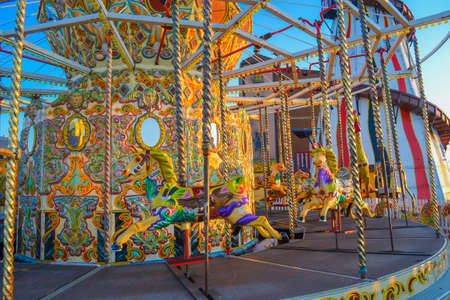 UK, Brigton, 01.10.2021: A carousel from Brighton Pier. The characters are horses and roosters, the back wall is also decorated and has mirrored inserts.のeditorial素材