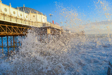 UK, Brighton, 01.10.2021: Photo of waves and splashes in the storm, the famous Brighton pier in the backgroundのeditorial素材