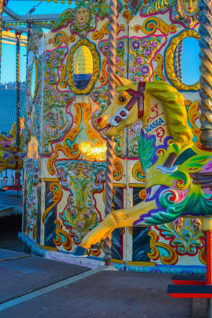 UK, Brigton, 01.10.2021: A carousel from Brighton Pier. The characters are horses and roosters, the back wall is also decorated and has mirrored inserts.のeditorial素材
