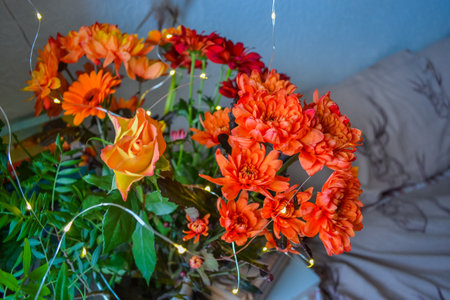 A bouquet of flowers, red as fire at home and a decoration of light. Flowers in a bouquet: Gerbera, Rose.の写真素材