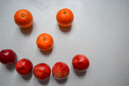 Four fruits: oranges, tangerines and peaches (nectarines) on a tableの写真素材