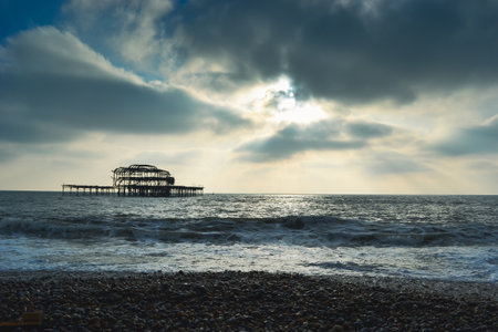 Burnt out Brighton Pier during a storm and sunsetの写真素材