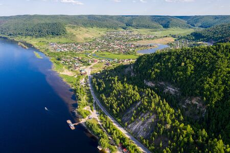Volga river landscape, big river and forest on mountain and village Shiryaevo on shoreの写真素材