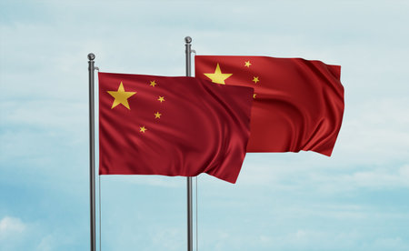Two China flag waving together on blue sky, two country cooperation conceptの写真素材