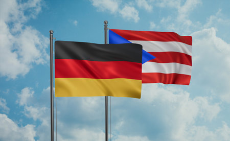 Puerto Rico and Germany flag waving together in the wind on blue sky, two country cooperation...