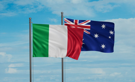 Australia flag and Italy flag waving together on blue sky, two country cooperation conceptの写真素材