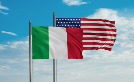USA and Italy flag waving together in the wind on blue sky, two country cooperation concept