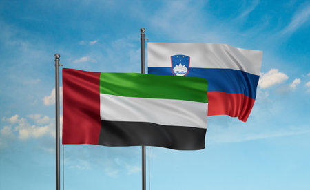 Slovenia and United Arab Emirates, UAE flag waving together in the wind on blue sky, two country cooperation conceptの写真素材