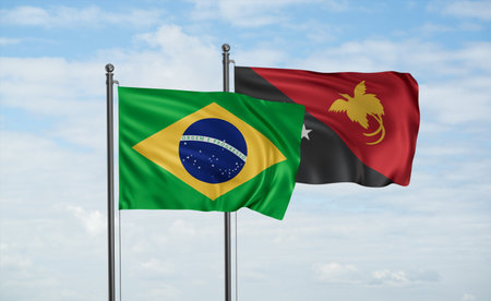 Papua New Guinea flag and Brazil flag waving together on blue sky, two country cooperation conceptの写真素材
