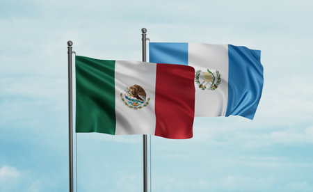 Guatemala flag and Mexico flag waving together on blue sky, two country cooperation conceptの写真素材
