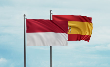 Spain and Indonesia and Bali island flag waving together in the wind on blue sky, two country cooperation conceptの写真素材
