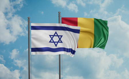 Republic of Guinea flag and Israel flag waving together on blue sky, two country cooperation conceptの写真素材