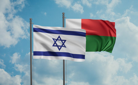 Madagascar flag and Israel flag waving together on blue sky, two country cooperation conceptの写真素材