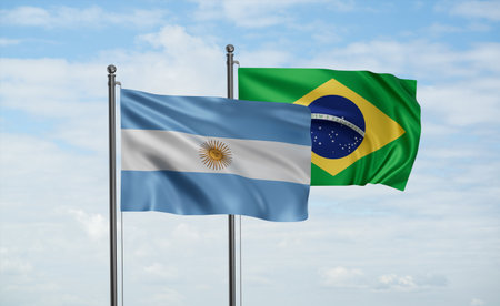 Brazil flag and Argentina flag waving together on blue sky, two country cooperation conceptの写真素材