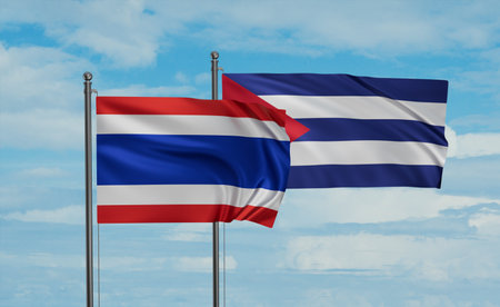 Cuba and Thailand flag waving together in the wind on blue sky, two country cooperation conceptの写真素材