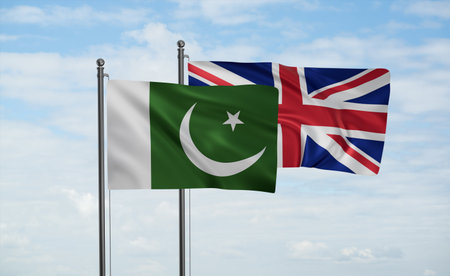 United Kingdom and Pakistan flag waving together in the wind on blue sky, two country cooperation conceptの写真素材