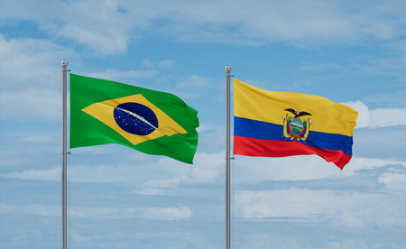 Ecuador and Brazil flags waving together on blue cloudy sky, two country relationship conceptの写真素材