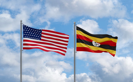 Republic of Uganda and USA flags waving together in the wind on blue cloudy sky, two country relationship conceptの写真素材