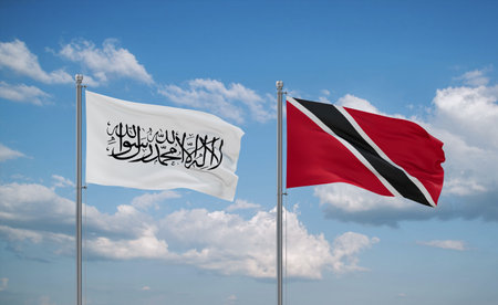 Trinidad and Tobago and Afghanistan flags waving together in the wind on blue cloudy sky, two country relationship conceptの写真素材