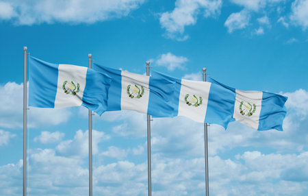 Guatemala four flags in row waving together on blue cloudy sky, multiple flags in lineの写真素材