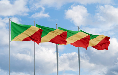 Republic of the Congo or Congo-Brazzaville four flags in row waving together on blue cloudy sky, multiple flags in lineの写真素材
