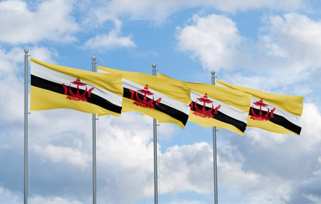 Brunei four flags in row waving together on blue cloudy sky, multiple flags in lineの写真素材